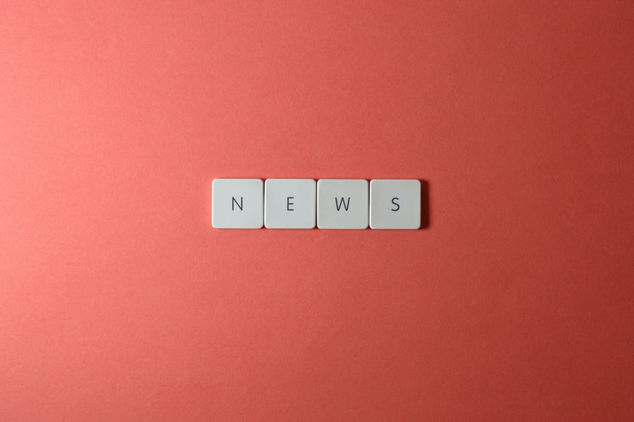 Offerings Close-up of keyboard keys spelling 'NEWS' on a red background, minimalist style.
