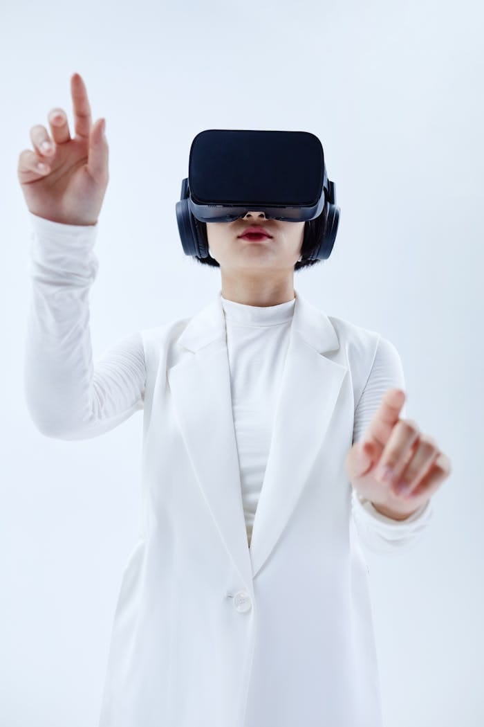 Portfolio Woman using VR headset, exploring technology in a white setting.